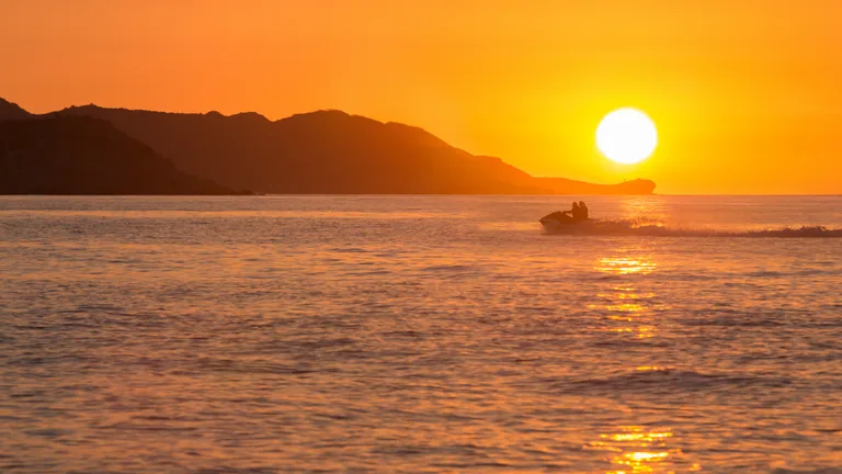 Jet ski sur une mer dorée au coucher du soleil, baie de Mandelieu