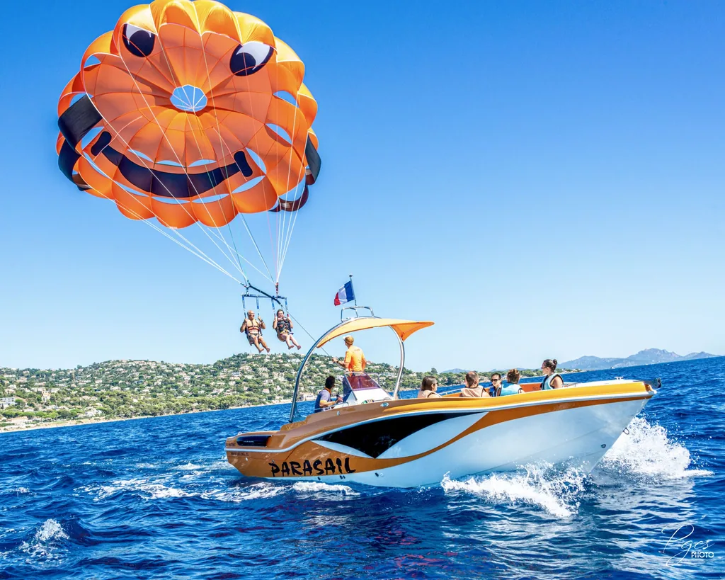 Parachute ascensionnel orange au-dessus du bateau dans la baie de Mandelieu – Théoule