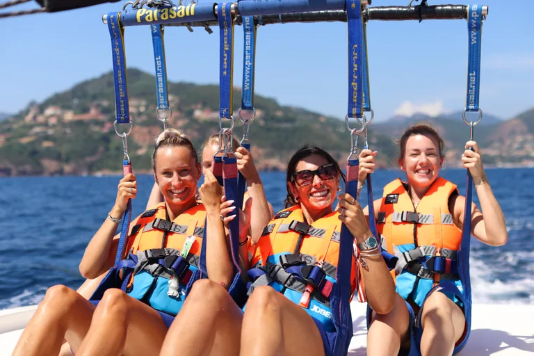 Trois amies harnachées sous le parachute ascensionnel, prêtes à décoller du bateau